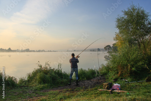 Man fishing on a lake with fog