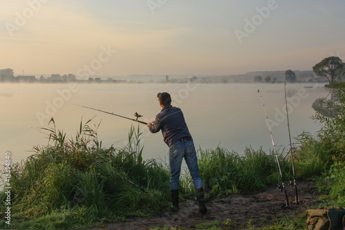 Man fishing on a lake with fog