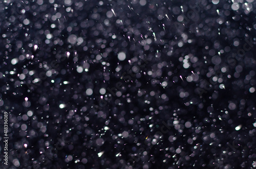 Falling snowflakes in the dark night.