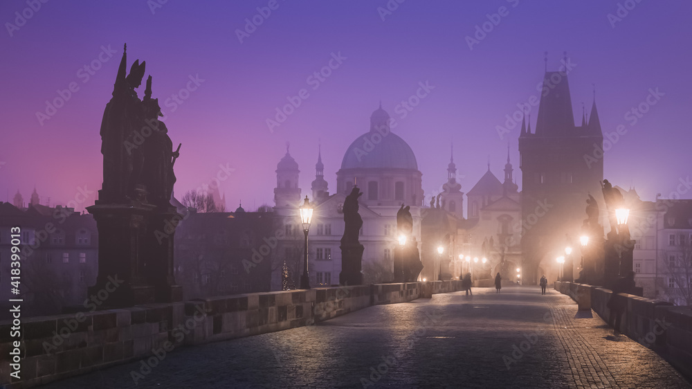 A quiet Gothic Charles Bridge at dawn with a moody, foggy atmosphere in old town Prague, Czech Republic.
