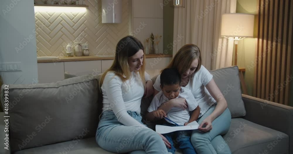 Mother and aunt Europeans help their little African American son draw. International family. High quality 4k footage Mother and aunt Europeans help their little African American son draw. International family. High quality 4k footage