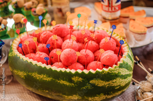 Fruit slicing at a wedding banquet. Watermelon, grapes, strawberry, orange, plum, pear, dinha, peach, kiwi, pineapple, persimmon, apple photo