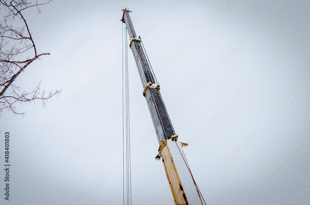 Loader crane with telescopic boom on a construction site. Loader crane with telescopic boom on a construction site.