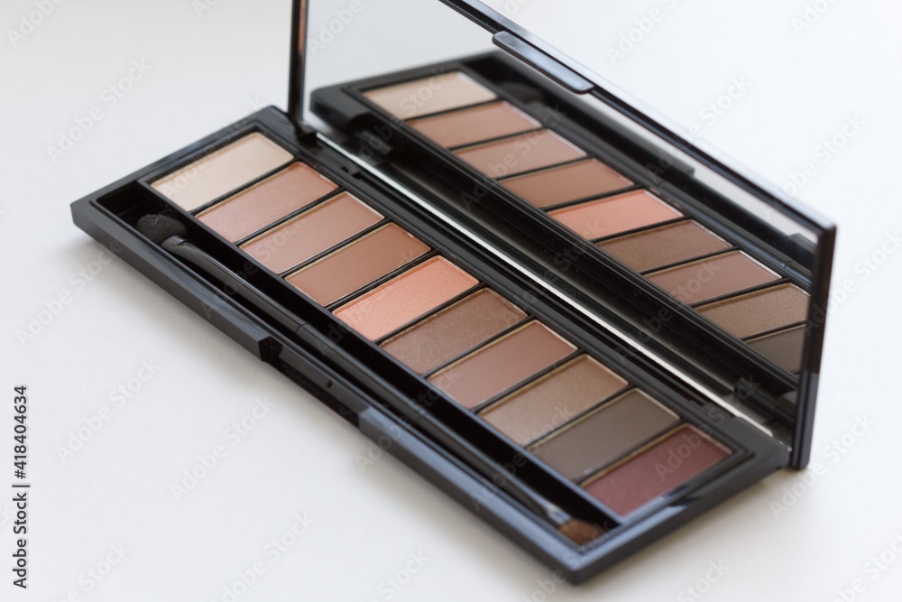 Make-up colorful eyeshadow palette with brushes closeup on a white background. Make-up colorful eyeshadow palette with brushes closeup on a white background.