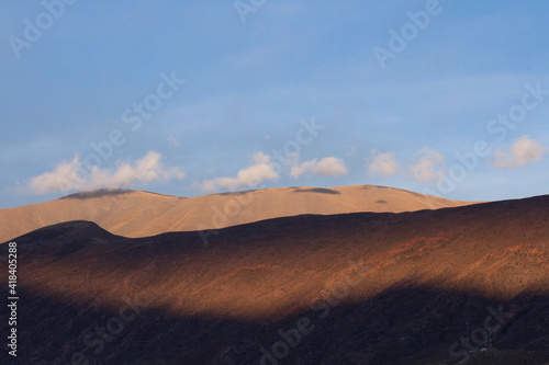 Poetic natural background. View of the Andes mountain range under a blue sky at sunset. The beautiful sunlight and shadow contrast in the mountains. 