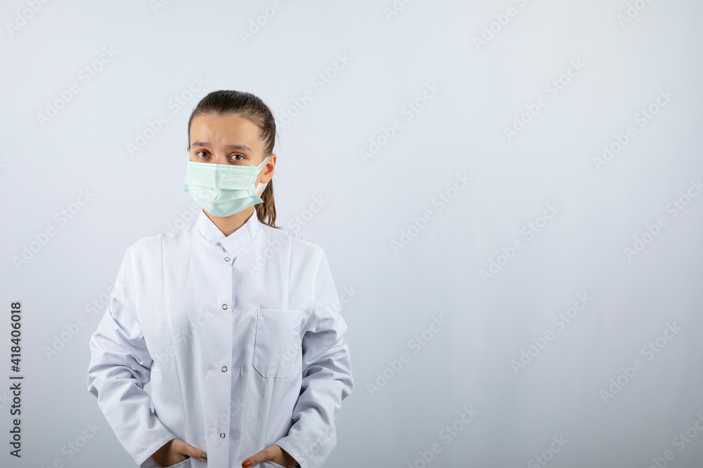 Woman doctor in white uniform wearing a medical mask Woman doctor in white uniform wearing a medical mask