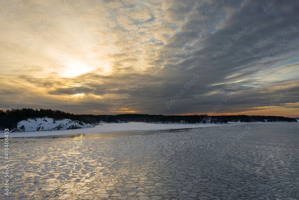 Sunset. Beautiful view of the northern snow covered shores of Scandinavia, Baltic sea at sunset time in winter. Amazing sky bright colors and clouds on the horizon. Winter landscape. Sunset. Beautiful view of the northern snow covered shores of Scandinavia, Baltic sea at sunset time in winter. Amazing sky bright colors and clouds on the horizon. Winter landscape.