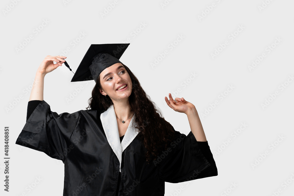 Graduate girl with master degree in black graduation gown and cap on white background. Happy young woman careerist have success in her business. Graduate girl with master degree in black graduation gown and cap on white background. Happy young woman careerist have success in her business.