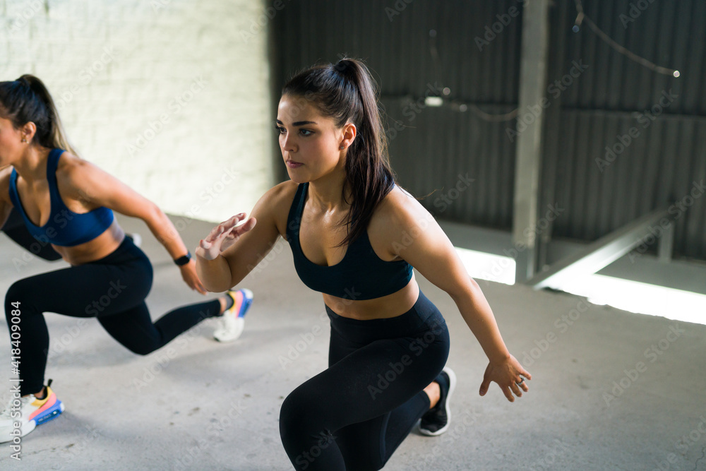 Fototapeta premium Active woman staying fit and doing leg lunges