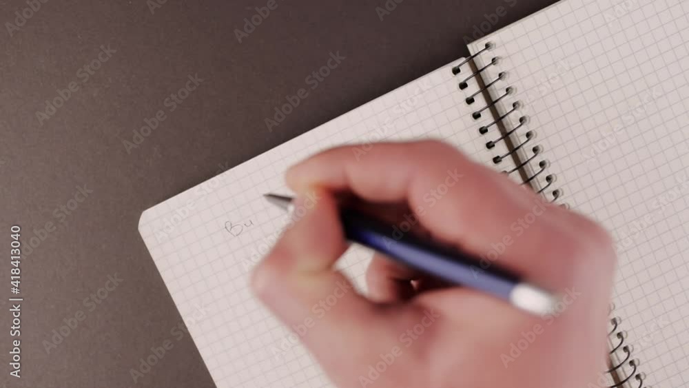a man writes in a notebook the word business plan a man writes in a notebook the word business plan