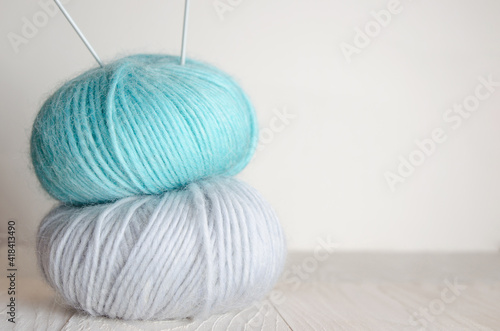 Two skeins of wool yarn on a light wooden background. Knitting 