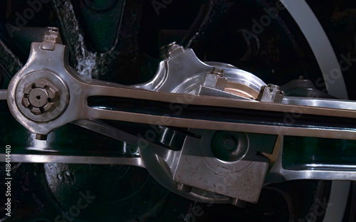 Close up of stream locomotive wheel connecting rods on black train wheel nobody