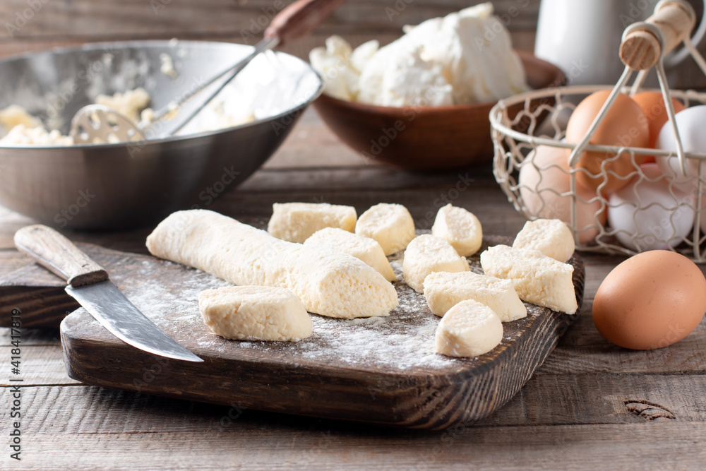 Raw lazy dumplings lie on a cutting board with a knife Raw lazy dumplings lie on a cutting board with a knife