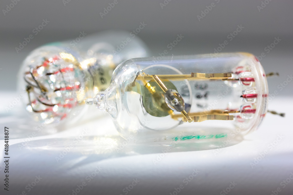 Two old electronic vacuum radio tubes isolated on white background. Transparent lamps produced by the Soviet Union. Vintage glass tube transistors close-up. Two old electronic vacuum radio tubes isolated on white background. Transparent lamps produced by the Soviet Union. Vintage glass tube transistors close-up.