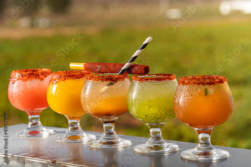 Refreshing Summer Vibes: A Variety of Flavored Margarita Shots in an Outdoor Restaurant and Bar