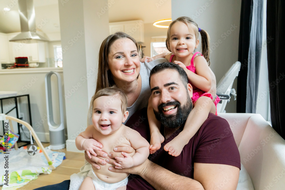 Portrait of happy family hugging in their home