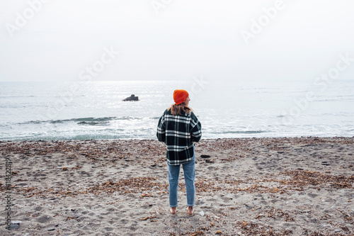 Woman on vacation with orange hat by the sea