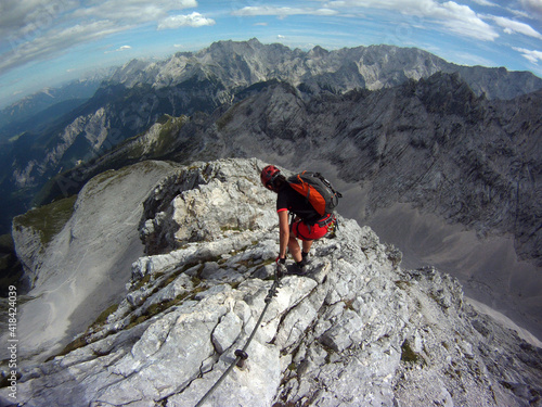 Woman cimbs over via ferrate alpspitz in the alpes germany adventure panorama scenic