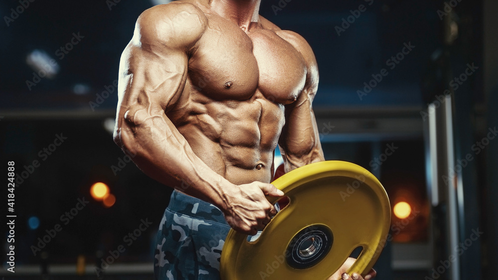 Fototapeta premium Brutal strong bodybuilder athletic men pumping up muscles with dumbbells.
