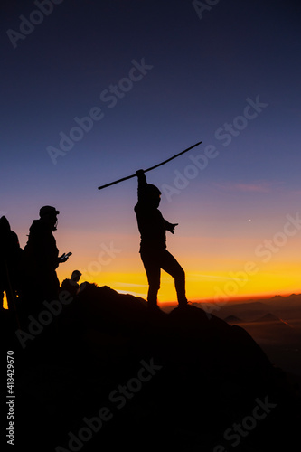 Silhouette woman climber at sunset on top of the Acatenango volcano in Guatemala-young woman reaching the goal of the excursion of her enjoying the last rays of sun on the volcano