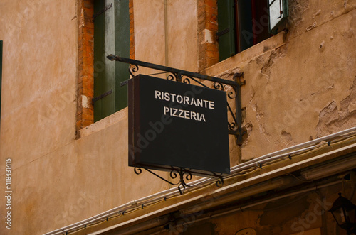 Italian signboard of a pizza restaurant on the background of an antiquated wall