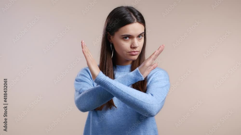 Cute girl disapproving with no crossing hands sign make basta, negation, enough gesture. Denying, Rejecting, Disagree, Portrait of pretty girl on white background Cute girl disapproving with no crossing hands sign make basta, negation, enough gesture. Denying, Rejecting, Disagree, Portrait of pretty girl on white background