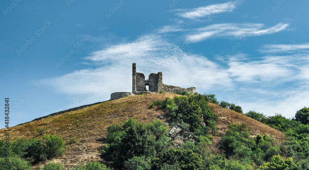 DEVIN, SLOVAKIA - JUNE 10, 2020: Ruins of Devin Castle on confluence of Danube an Morava rivers near Bratislava. View from river, against blue sky.