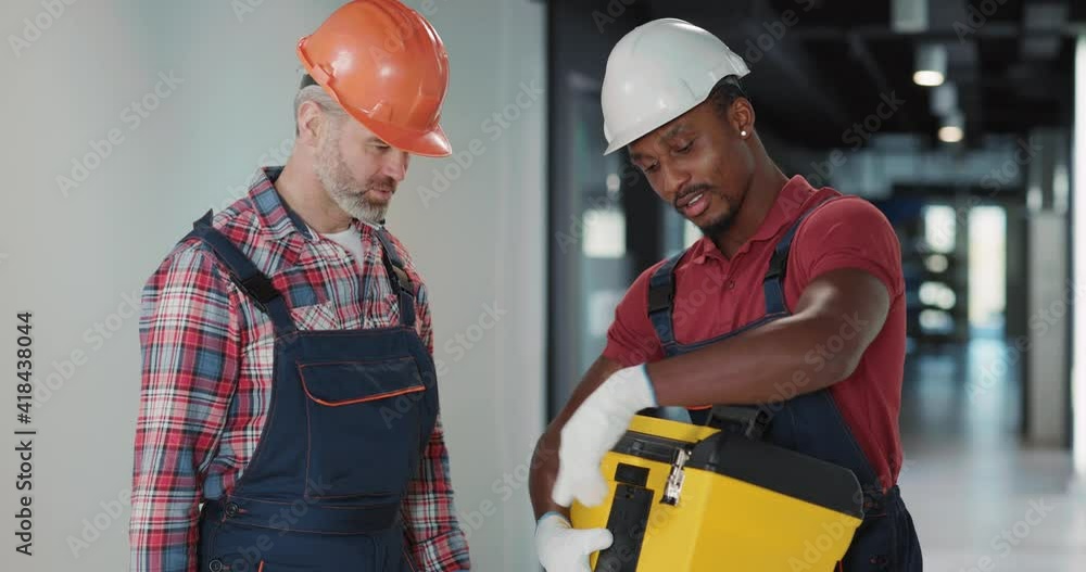 Couple of heavy indiustry workers preparing for operative work. African ...