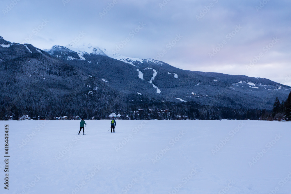 Cross country skier on frozen winter lake in Whistler, BC.