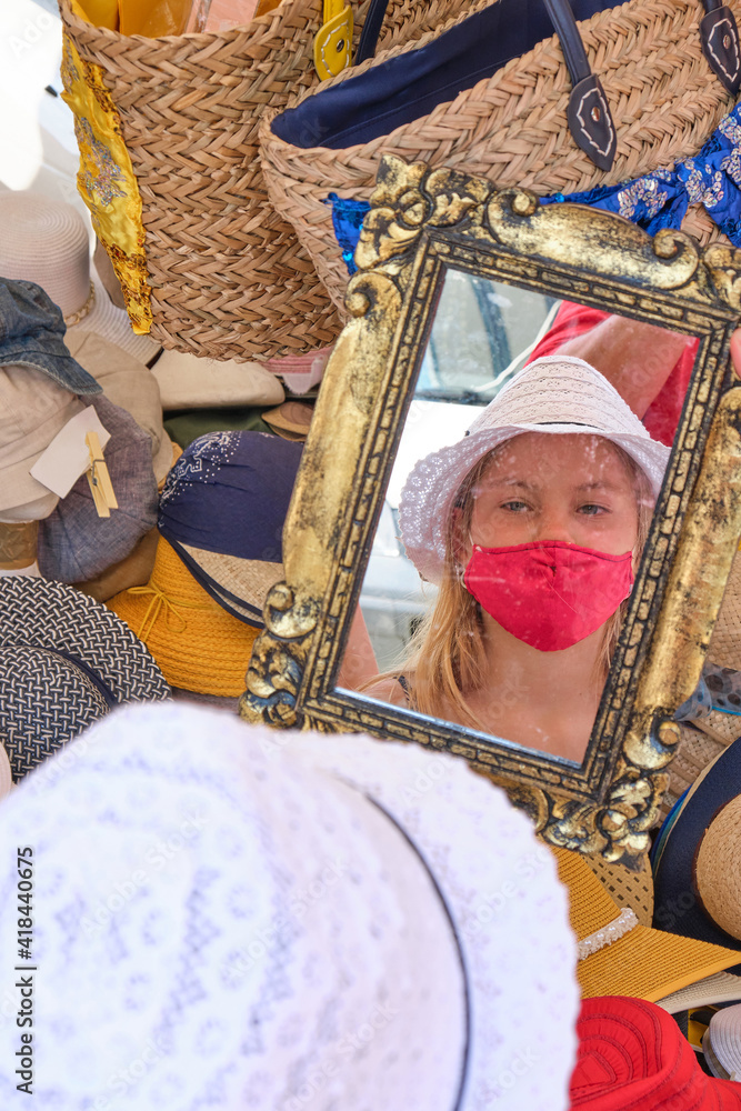 Obraz premium little girl at the marketplace in Luino (Lombardy) in Italy, Girl wearing a face mask during pandemic coronavirus.