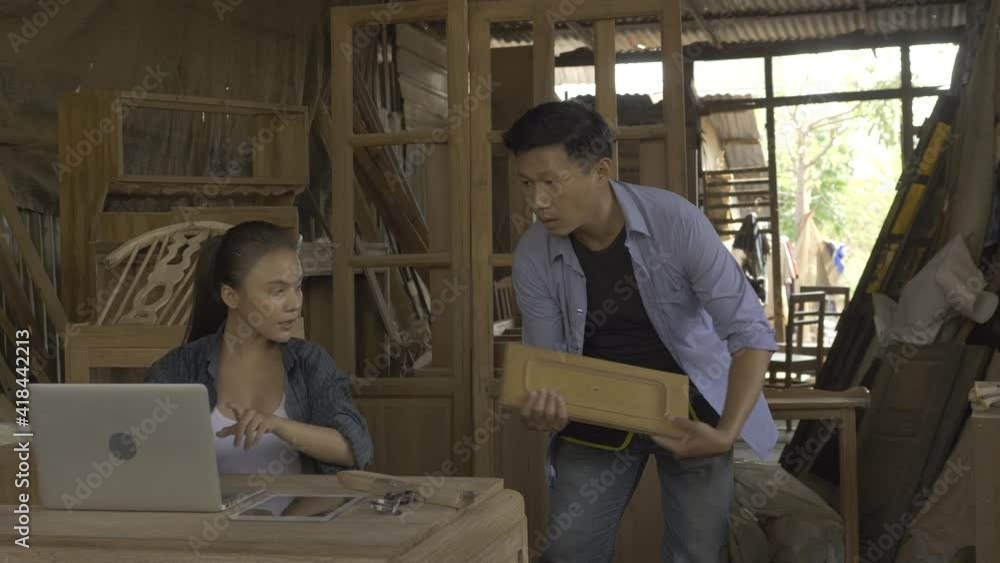 Asian women and men are skilled carpenters holding a tablet, selling wood furniture online, selling things on the website Asian women and men are skilled carpenters holding a tablet, selling wood furniture online, selling things on the website