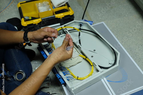 Technicians are cutting and fusion fiber optic cables. photo