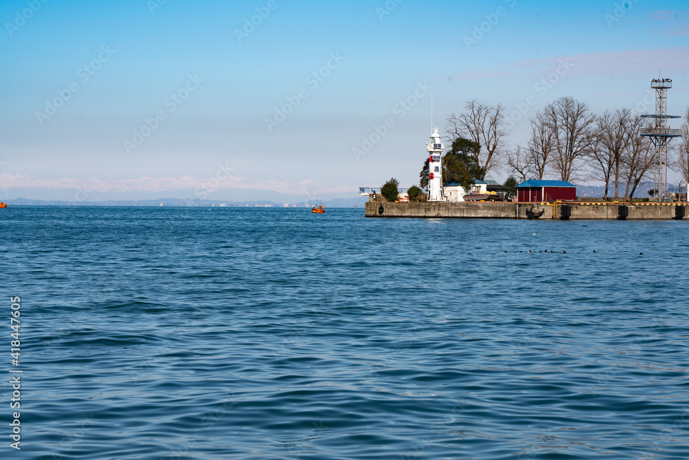 View of the lighthouse from the shore in the seaport of the city of Batumi, Adjara, Georgia