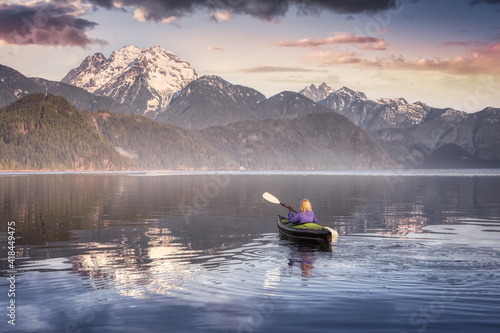 Adventurous Girl kayaking on an infatable kayak in a beautiful lake. Colorful peaceful Sunrise Art Render. Taken in Stave Lake, East of Vancouver, British Columbia, Canada. Adventure and vacation photo