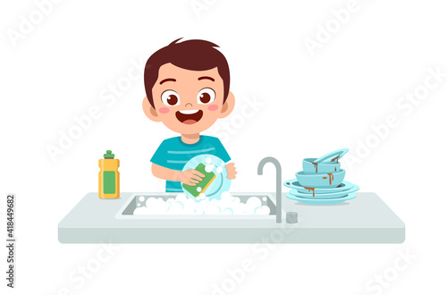 happy cute little boy washing dish in the kitchen