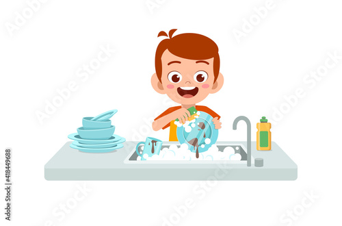 happy cute little boy washing dish in the kitchen
