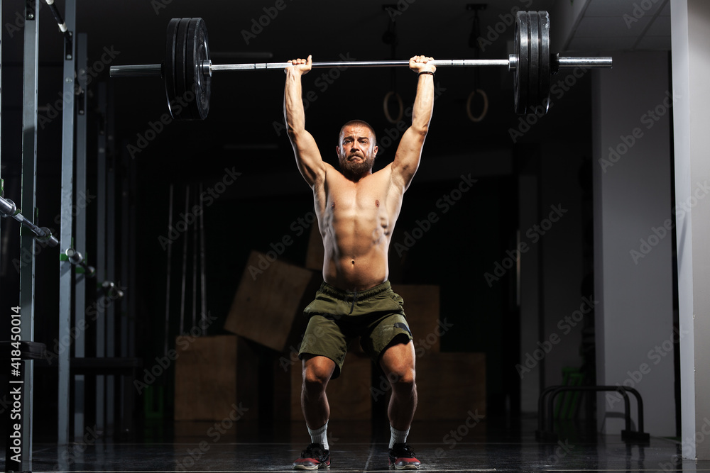 Naklejka premium Muscular athlete lifting very heavy barbell