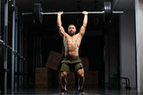 Muscular athlete lifting very heavy barbell