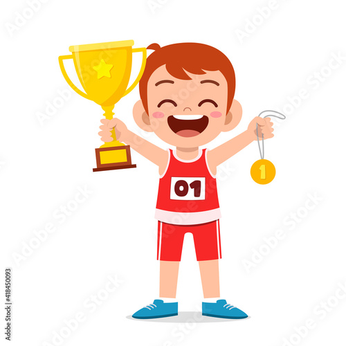 happy cute little boy holding gold medal and trophy