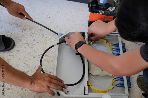 Technicians are cutting and fusion fiber optic cables. photo