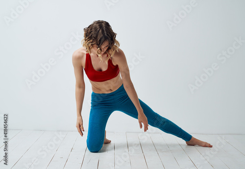 Woman in sportswear doing yoga asana exercises model light room