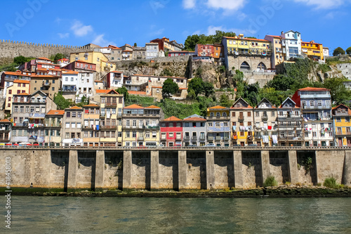 typical Porto houses next to the Douro River, picturesque architecture of lined houses and bright colors. Portugal.