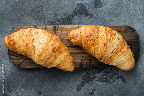 Crispy fresh croissants, on gray stone background, top view flat lay