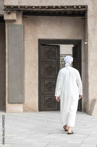 arab man in traditional clothing walking in old Dubai