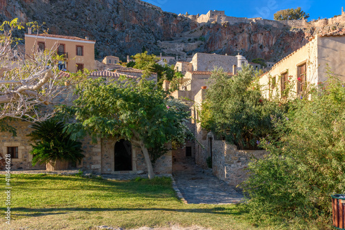 Traditional architecture with narrow stone street and a colorfull bougainvillea in the medieval castle of Monemvasia, Lakonia, Peloponnese, Greece. 