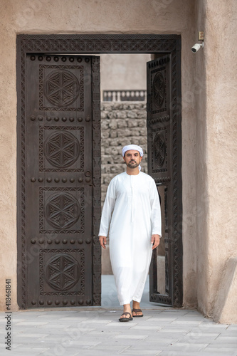 arab man in traditional clothing coming out of a door