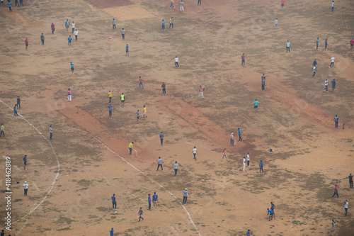 people crowding and playing cricket match with social distancing on playground during lockdown in Mumbai