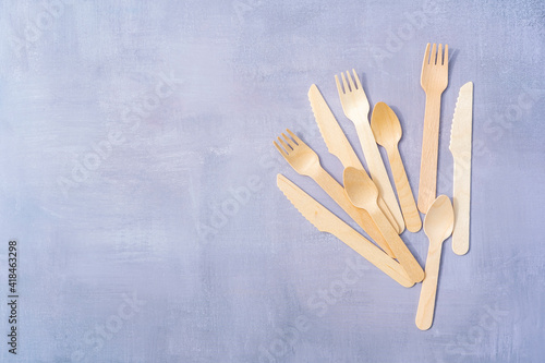 Eco Friendly Disposable tableware from natural materials. Wooden cutlery on natural gray stone background. Top view copy space
