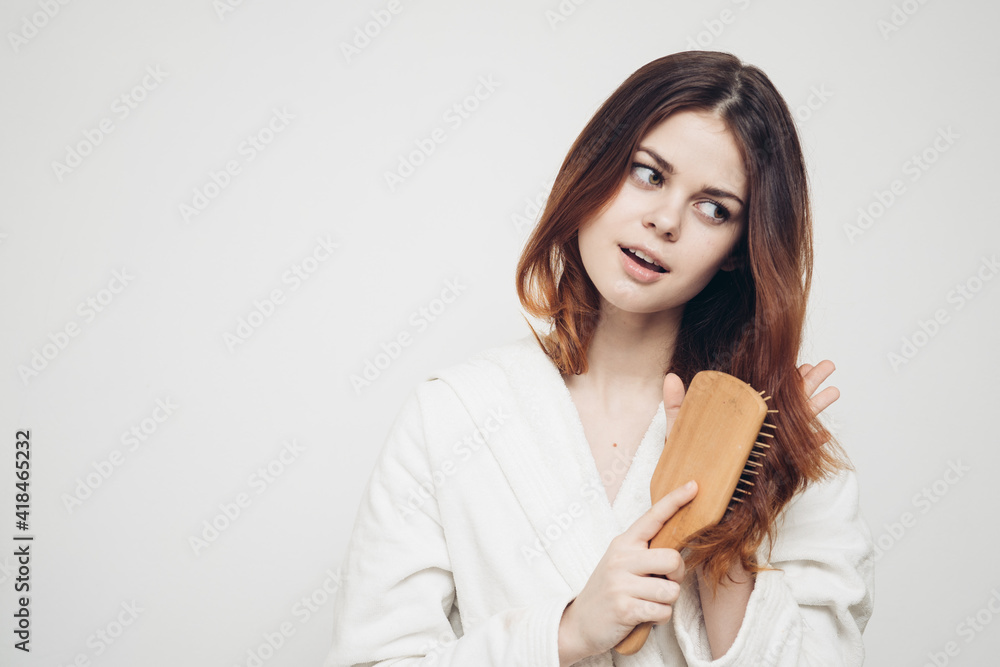 red-haired woman in light clothes combing her hair with Copy space red-haired woman in light clothes combing her hair with Copy space
