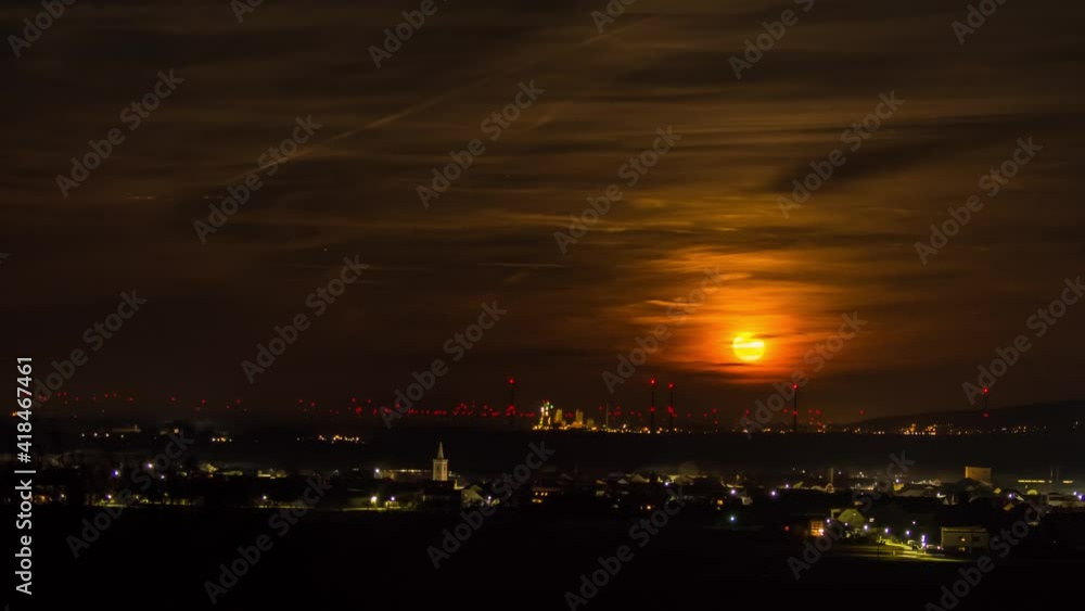 Time lapse sunrise full moon with clouds and a rural village Time lapse sunrise full moon with clouds and a rural village